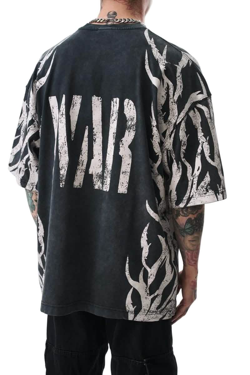 Person wearing a black t-shirt with white text and graphics on a plain background