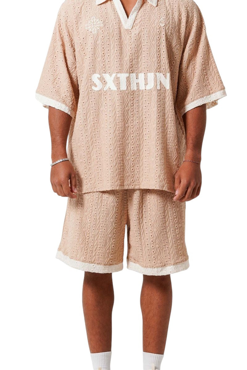 On Time Fashions beige crochet resort set with embroidered logo on shirt and shorts.
