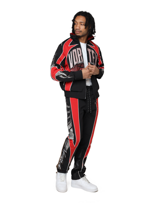 Person wearing a black and red tracksuit with visible branding on a white background