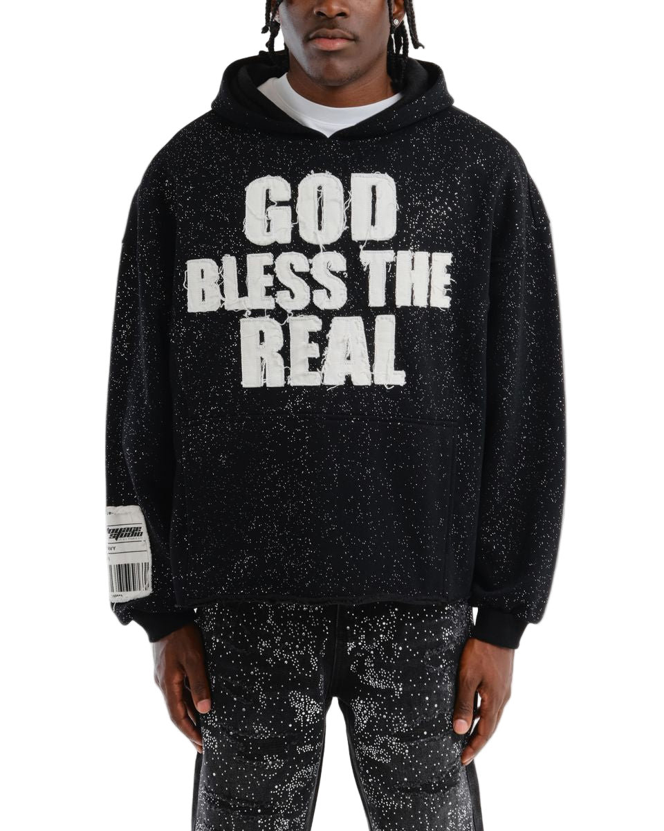 Person wearing a black hoodie with 'GOD BLESS THE REAL' text on a white background