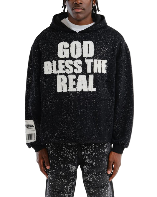 Person wearing a black hoodie with 'GOD BLESS THE REAL' text on a white background