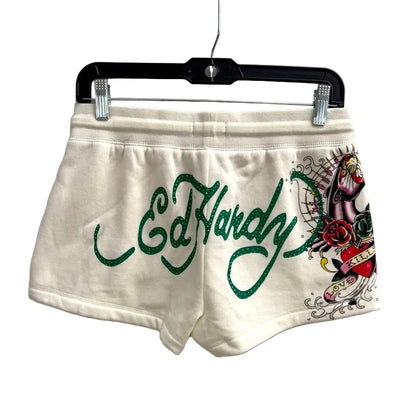 White shorts with 'Ed Hardy' logo and design on a hanger against a white background