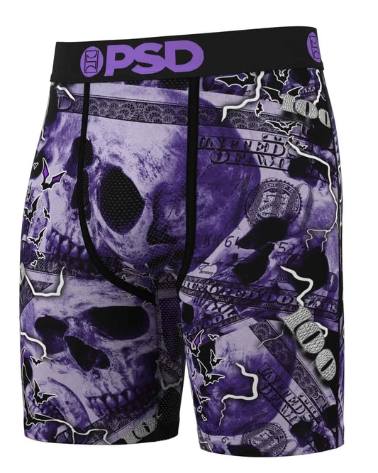 Purple and black shorts with skull and money design, featuring the brand 'PSD'.
