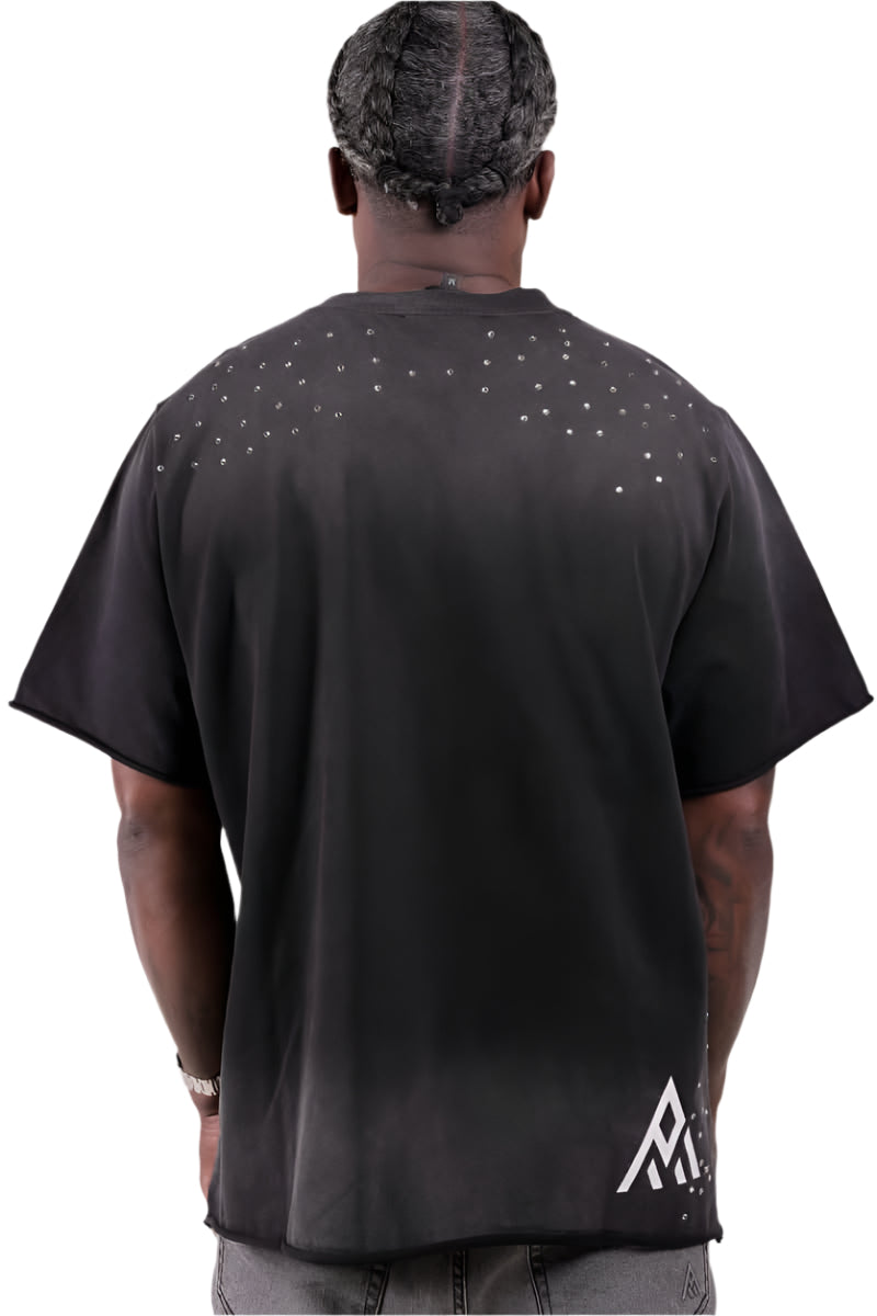 Person wearing a black t-shirt with a logo on the back, standing against a plain background