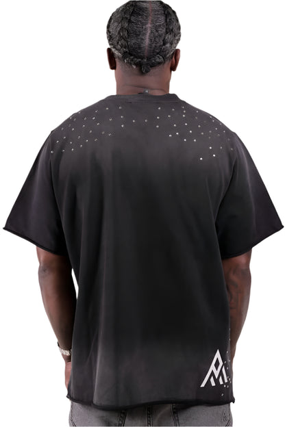 Person wearing a black t-shirt with a logo on the back, standing against a plain background