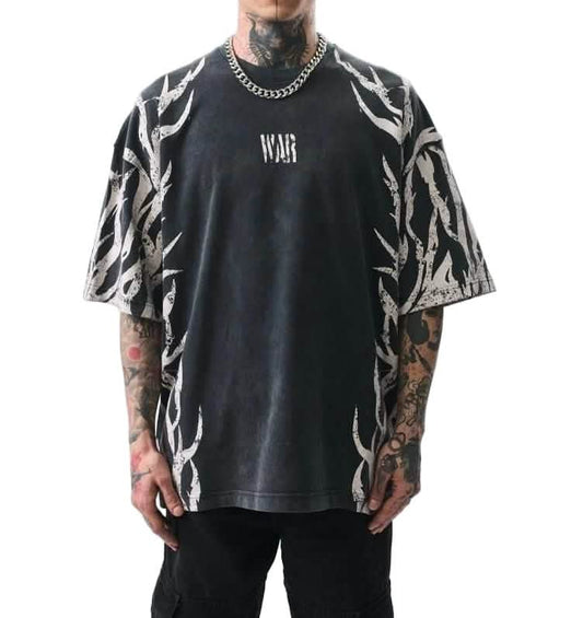 Man wearing a black t-shirt with white patterns and text, standing against a white background