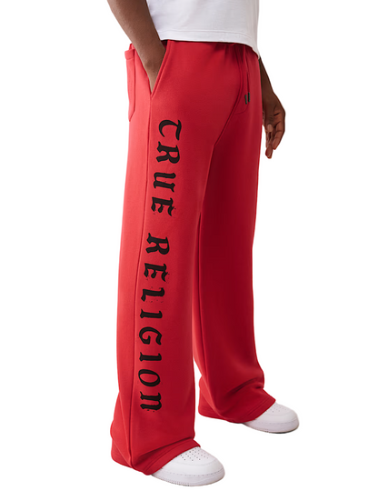 Red 'True Religion' sweatpants worn by a person on a white background