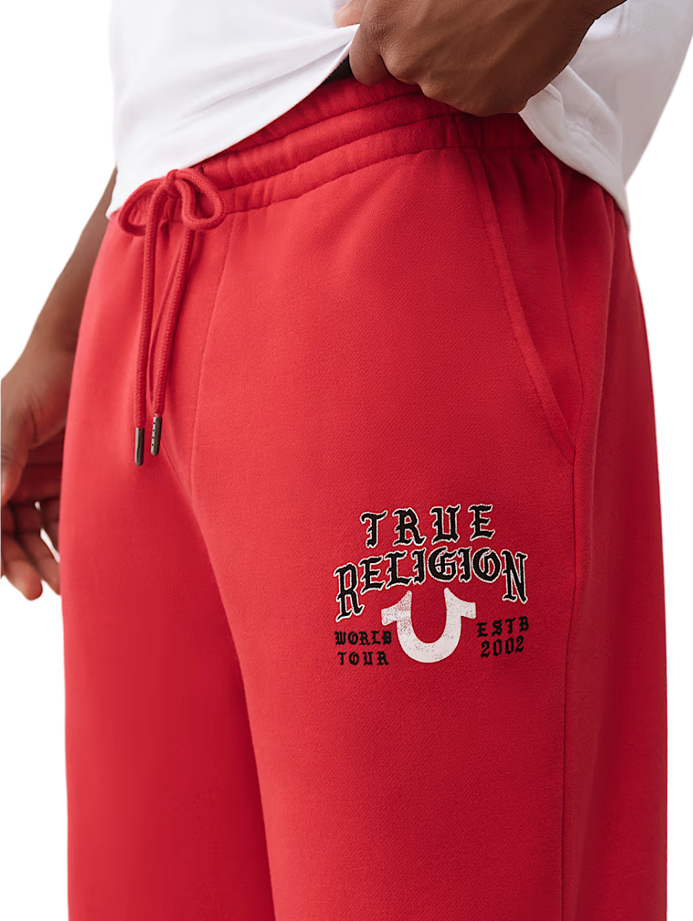 Red sweatpants with 'True Religion' logo on a white background