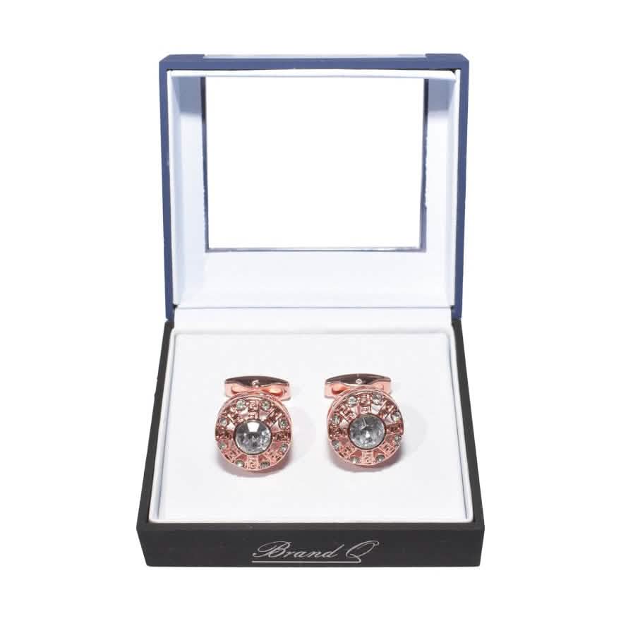 Rose gold cufflinks with gemstones in a branded box on a white background