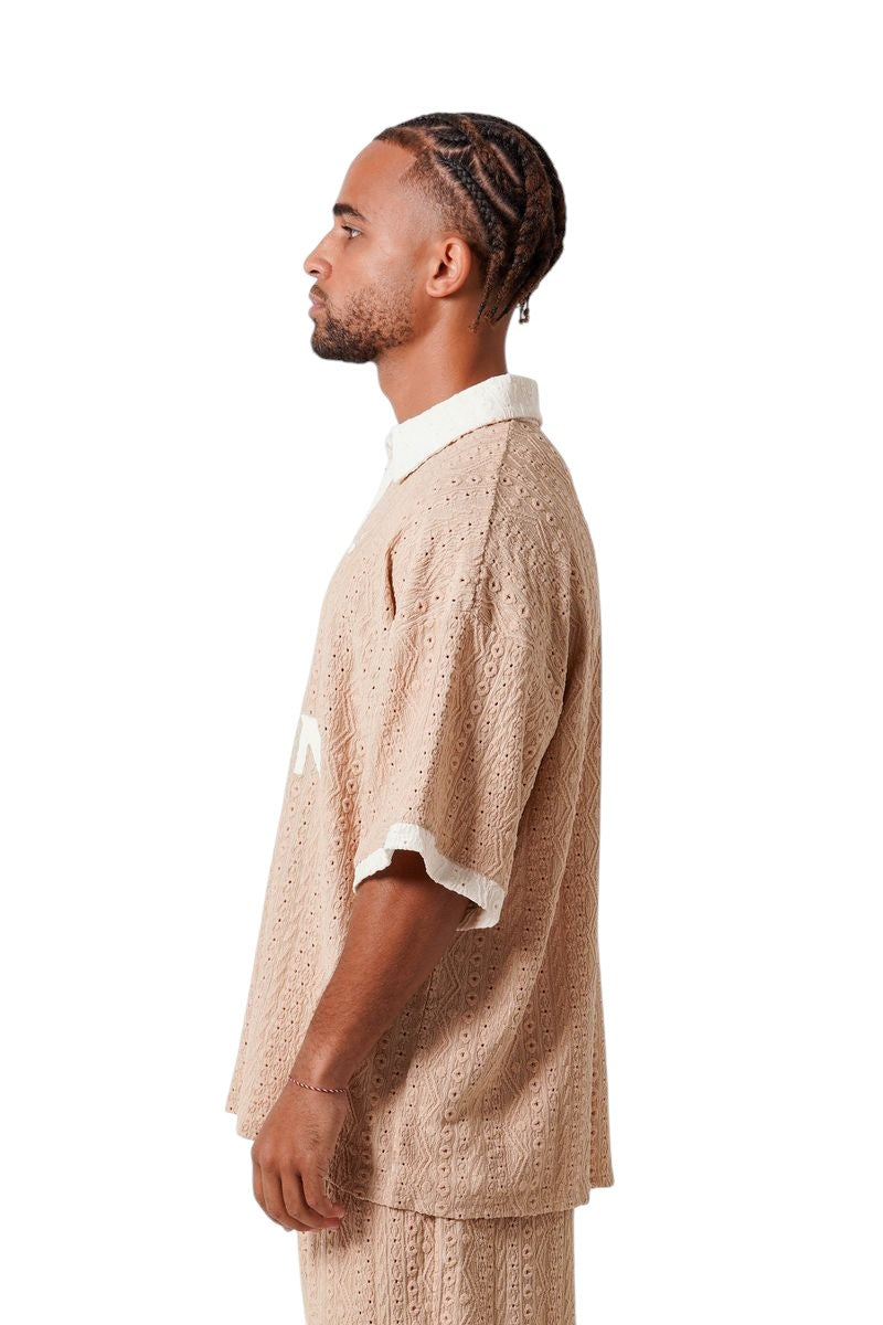 On Time Fashions beige crochet resort set with embroidered logo on short-sleeved tee and shorts.
