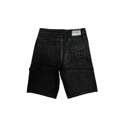 On Time Fashions black wax denim worker shorts with gothic 'M' logo on back pockets and 'emotion' logo patch.