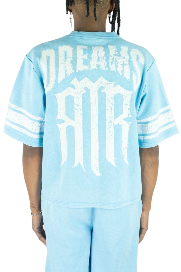 On Time Fashions light blue cotton jersey with white 'DREAMS' and gothic 'MR' graphic print. Features striped sleeves.