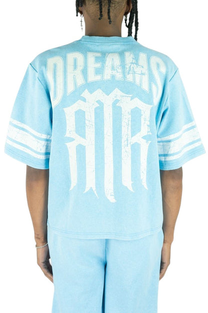 On Time Fashions light blue cotton jersey with white 'DREAMS' and gothic 'MR' graphic print. Features striped sleeves.