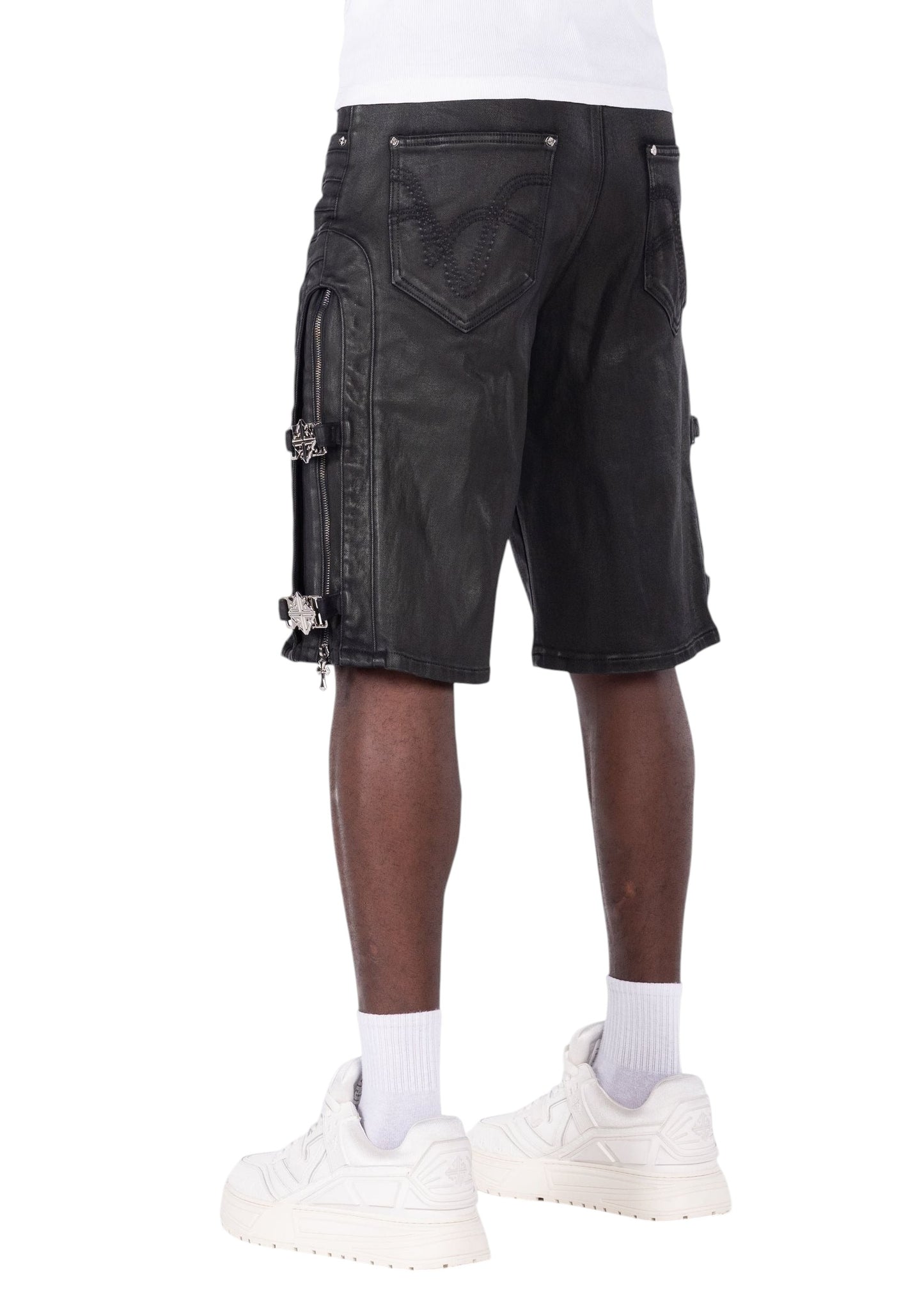 On Time Fashions Guapi all black denim shorts with cross buckle side straps and curved panel detailing on a model