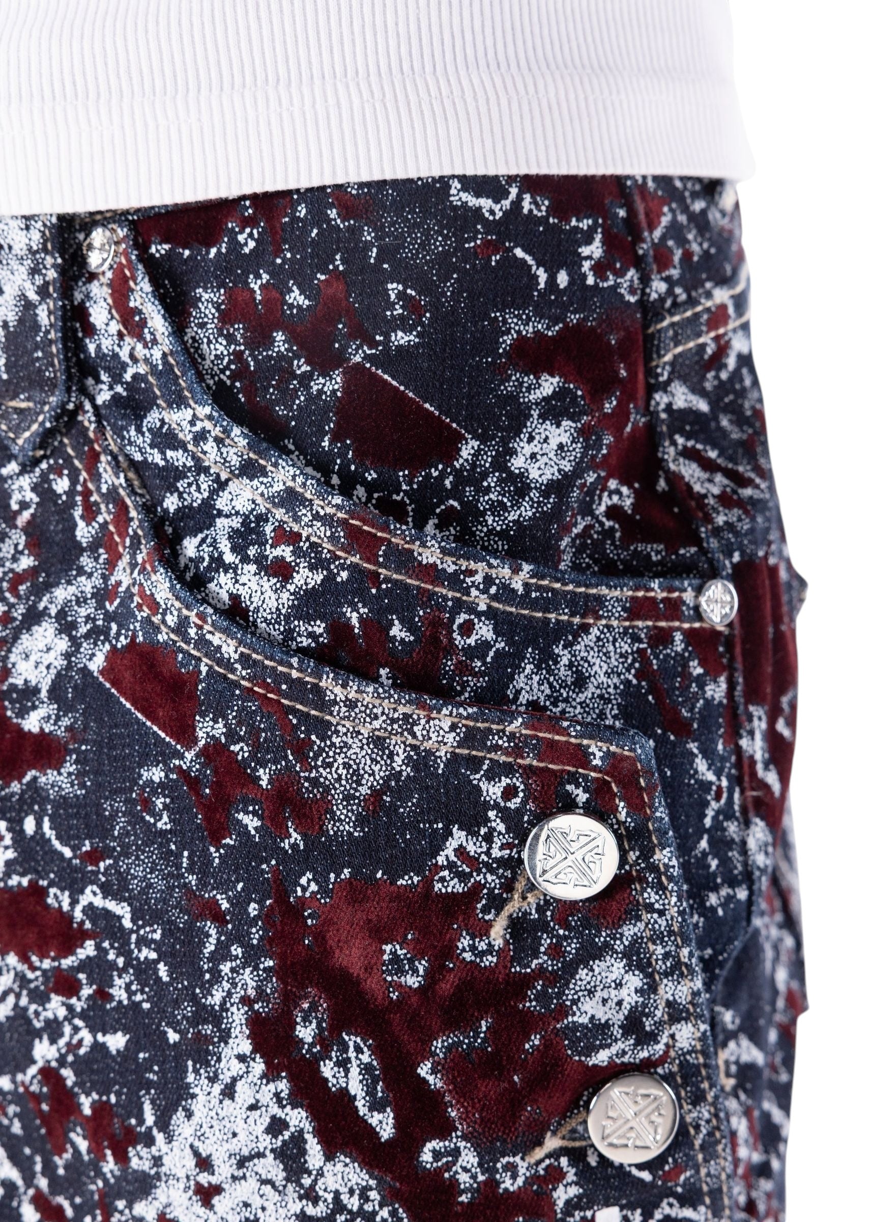 On Time Fashions Guapi wine red velvet shorts with laser-etched abstract marble pattern and metallic logo buttons.
