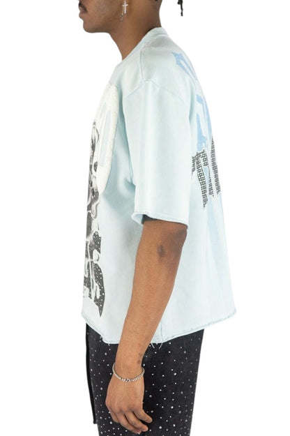 On Time Fashions light blue Rebel Minds crop tee with skull and rose graphic, rhinestones, and raw-edge hem.