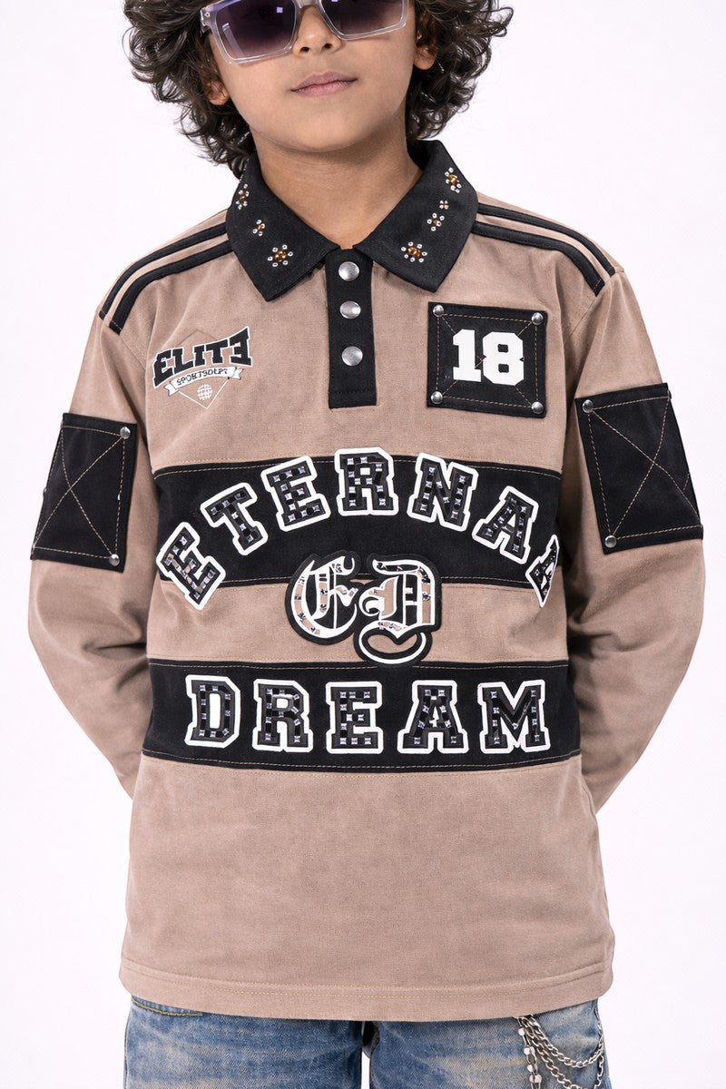 On Time Fashions kid's tan long-sleeve polo with black collar, "Eternal Dream" graphic, and embellished details.