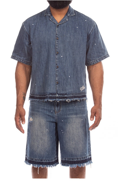 On Time Fashions blue denim short sleeve shirt with paint splatter and raw frayed hem.