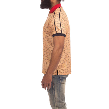 On Time Fashions Akoo Captain Polo shirt in tan with all-over print, red collar, and dark trim on sleeves.