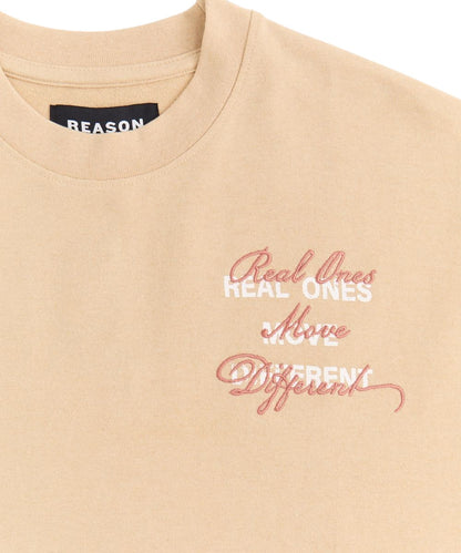 On Time Fashions beige terry crewneck t-shirt with embroidered "Real Ones Move Different" graphic.