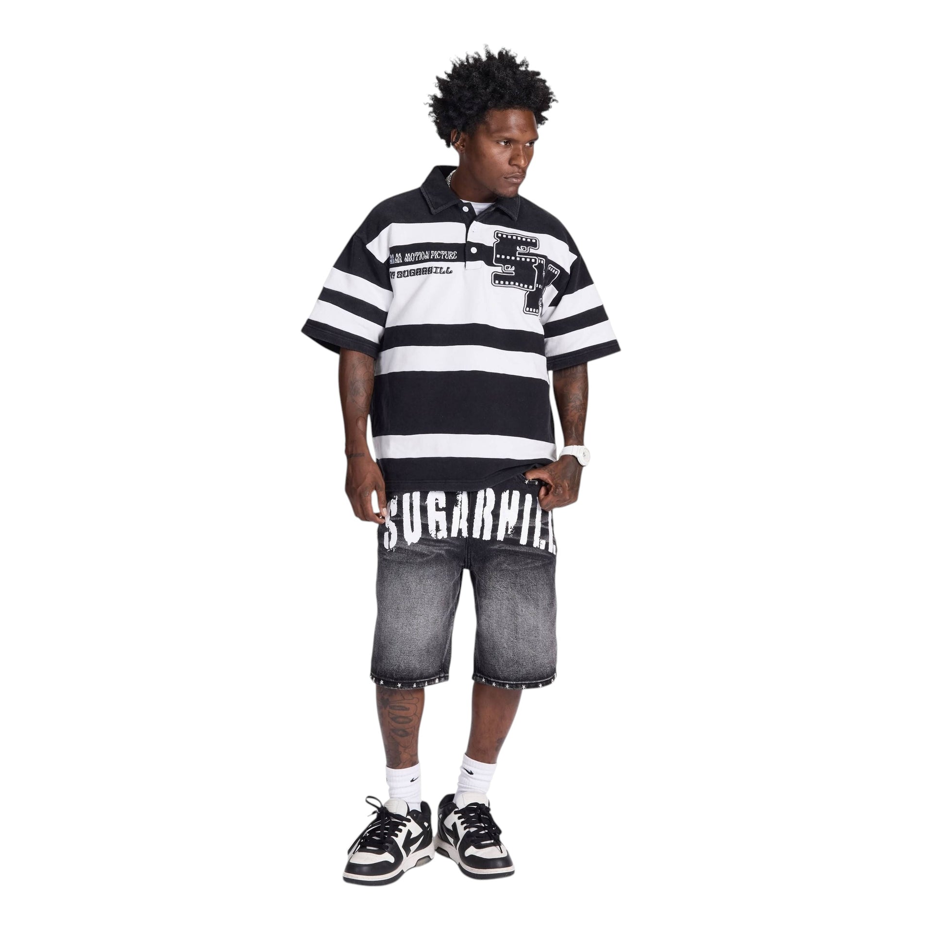 On Time Fashions men's black and grey distressed denim jorts with white "SUGARHILL" graphic waistband and studded hem.