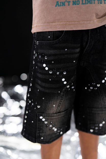 On Time Fashions black distressed denim shorts for kids, embellished with rhinestones and white paint splatters.
