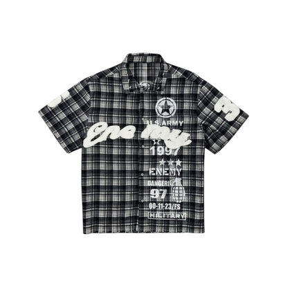 On Time Fashions black and white plaid short-sleeve shirt with graphic text and military-inspired designs.