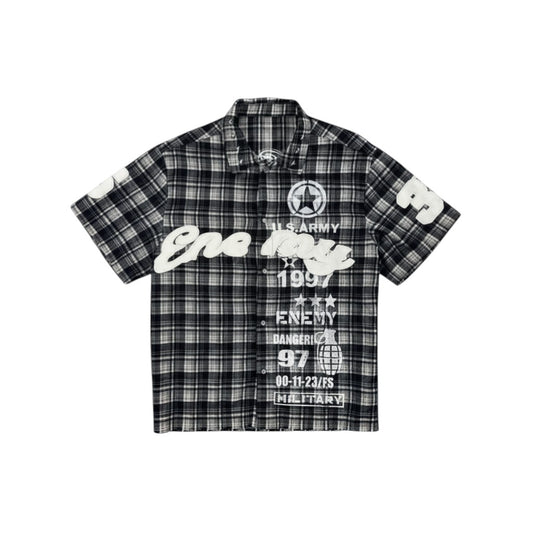 On Time Fashions black and white plaid short-sleeve shirt with graphic text and military-inspired designs.