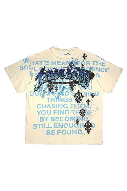 On Time Fashions cream 100% cotton relaxed fit tee with blue text graphic and rhinestone detailing.