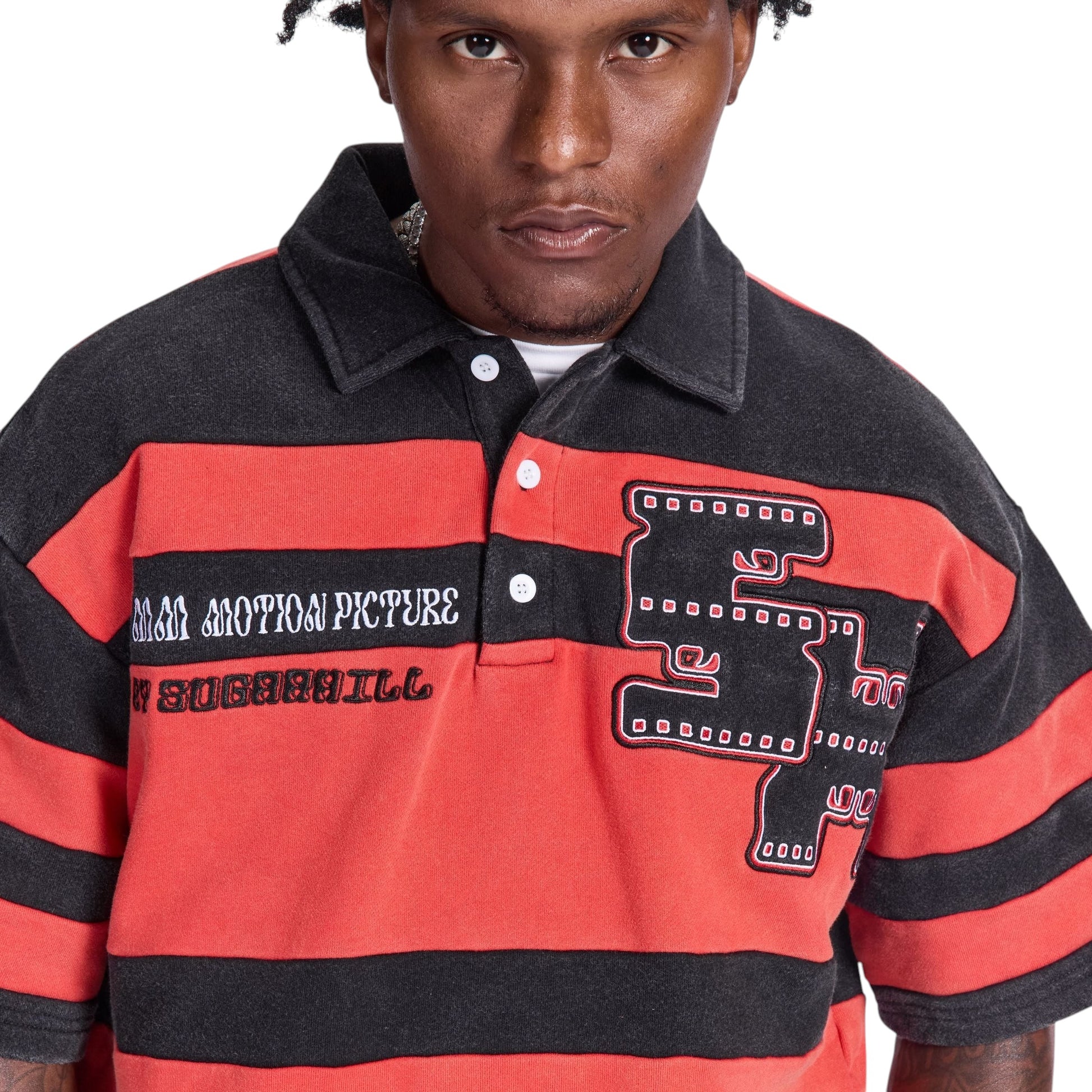 On Time Fashions men's red and black striped polo shirt with "MM MOTION PICTURE" and "SUGARHILL" embroidery and a film reel graphic.