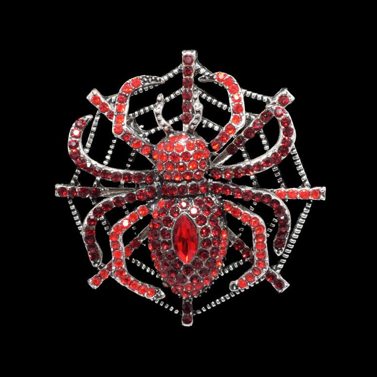 Red spider-shaped brooch with gemstones on a black background